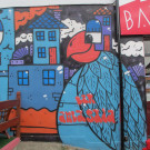 Mural featuring a bird with a building forming part of its head